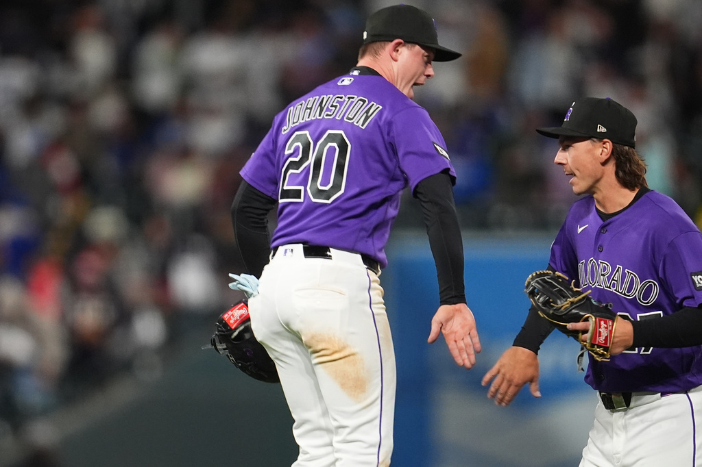 Colorado Rockies first baseman Troy Johnston, left, celebrates with left fielder Jordan Beck after defeasting the Los Angeles Dodgers in a baseball game Saturday, April 18, 2026, in Denver. (AP Photo/David Zalubowski)