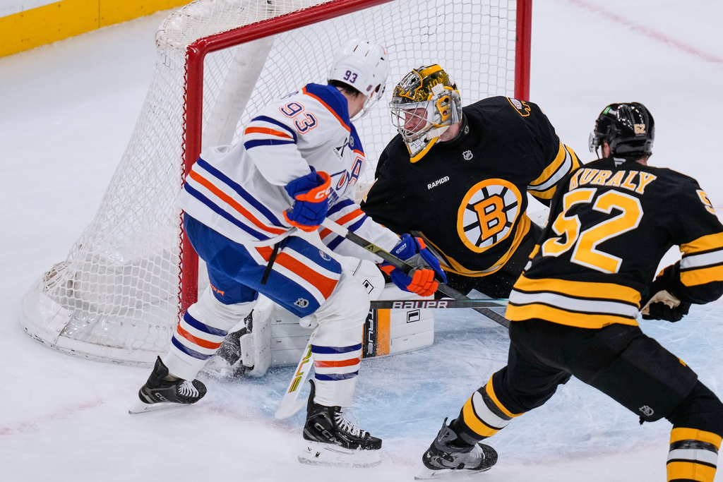 Edmonton Oilers center Ryan Nugent-Hopkins (93) scores against Boston Bruins goaltender Jeremy Swayman, top right, during the first period of an NHL hockey game, Thursday, Dec. 18, 2025, in Boston. (AP Photo/Charles Krupa)