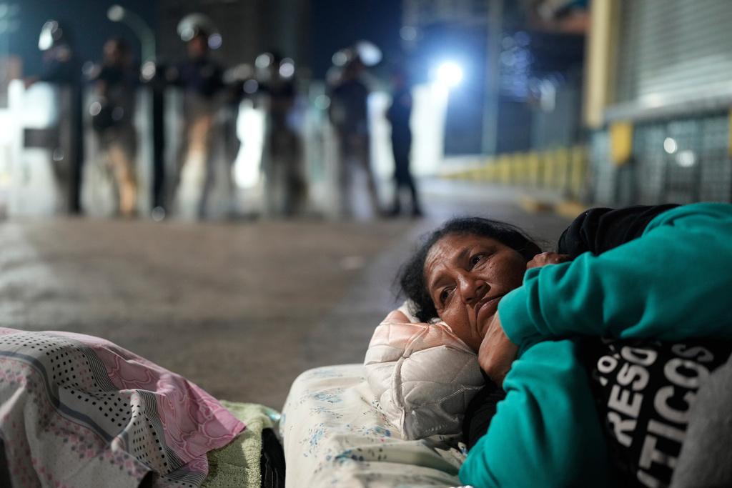 Nelsy Escorcia lies outside the Zone 7 detention center of the Bolivarian National Police, where her husband, Franklin Parra, is being held, as she waits for his release in Caracas, Venezuela, Saturday, Feb. 14, 2026. (AP Photo/Ariana Cubillos)