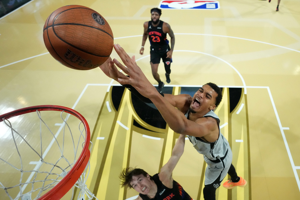 San Antonio Spurs forward Victor Wembanyama, right, dunks the ball past New York Knicks guard Tyler Kolek in the second half of an NBA Cup championship basketball game, Tuesday, Dec. 16, 2025, in Las Vegas. (Kirby Lee/Pool Photo via AP)