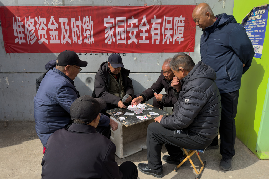 Elderly men play cards at a residential complex for former and current coal miners in Datong, China, Saturday, March 14, 2026. (AP Photo/Ng Han Guan)