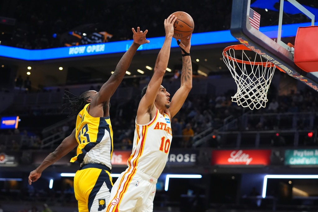 Atlanta Hawks' Zaccharie Risacher (10) dunks against Indiana Pacers' Aaron Nesmith (23) during the second half of an NBA Cup basketball game, Friday, Oct. 31, 2025, in Indianapolis. (AP Photo/Darron Cummings)