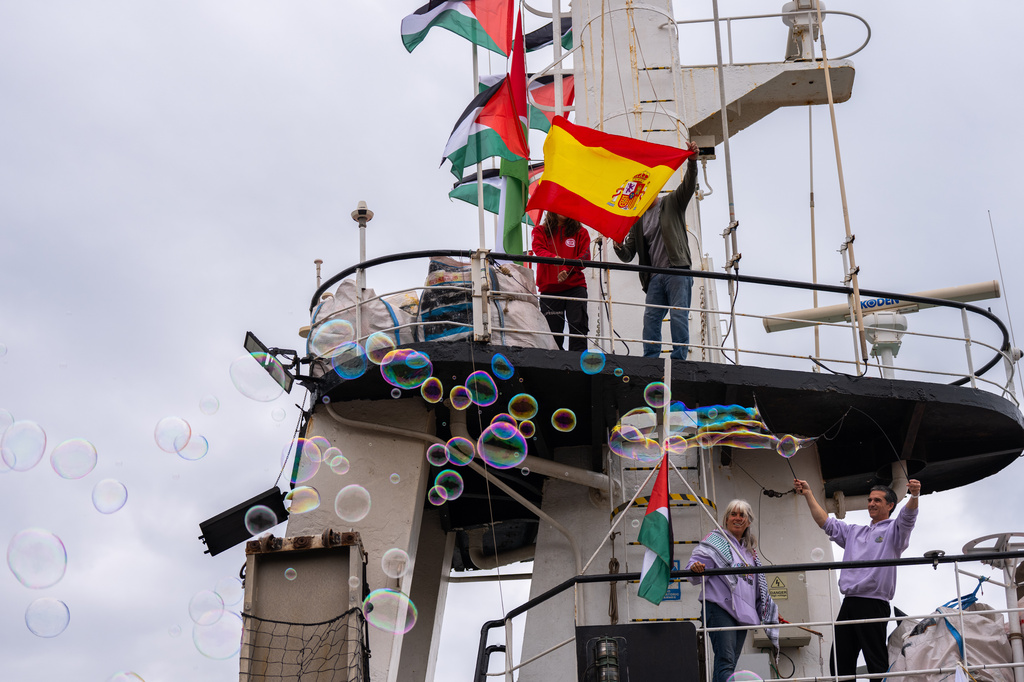Activists place Spanish and Palestinian flags on boats ahead of a Global Sumud Flotilla's planned departure bound for Gaza, in Barcelona, Spain, Sunday, April 12, 2026. (AP Photo/Joan Mateu Parra)