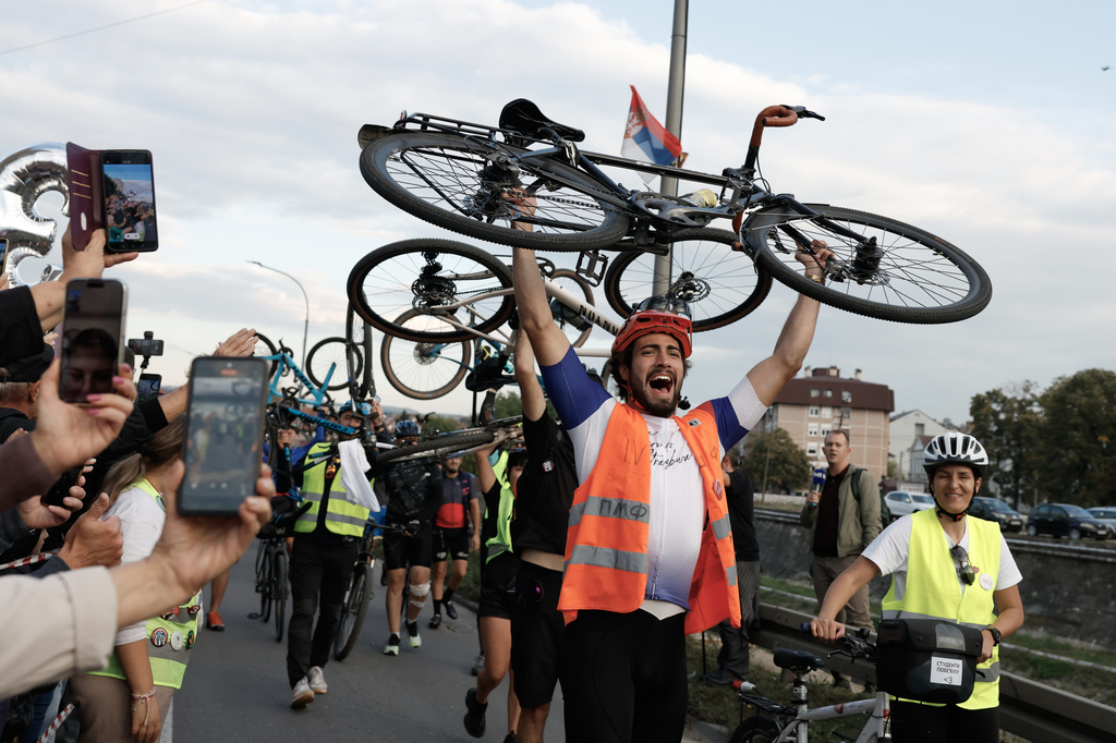 People welcome a group of university students at the end of their cycling tour of the Balkan country ahead of an early election next month challenging populist President Aleksandar Vucic, in Kragujevac, Serbia, Saturday, Sept. 26, 2026. (AP Photo/Marko Drobnjakovic)