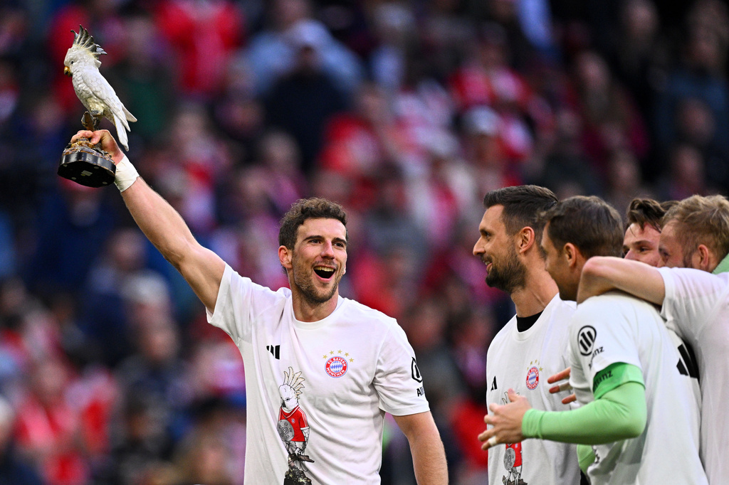 Bayern's Leon Goretzka, holds a cockatoo trophy as he celebrates after winning the German championship at the end of the Bundesliga soccer match between Bayern and Stuttgart in Munich, Germany, Sunday, April 19, 2026. (Tom Weller/dpa via AP)