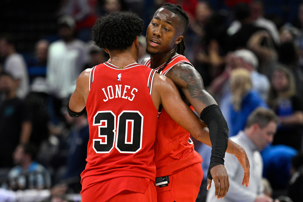 Chicago Bulls guard Tre Jones (30) and guard Ayo Dosunmu congratulate each other after a win against the Orlando Magic in an NBA basketball game, Saturday, Oct. 25, 2025, in Orlando, Fla. (AP Photo/Phelan M. Ebenhack)