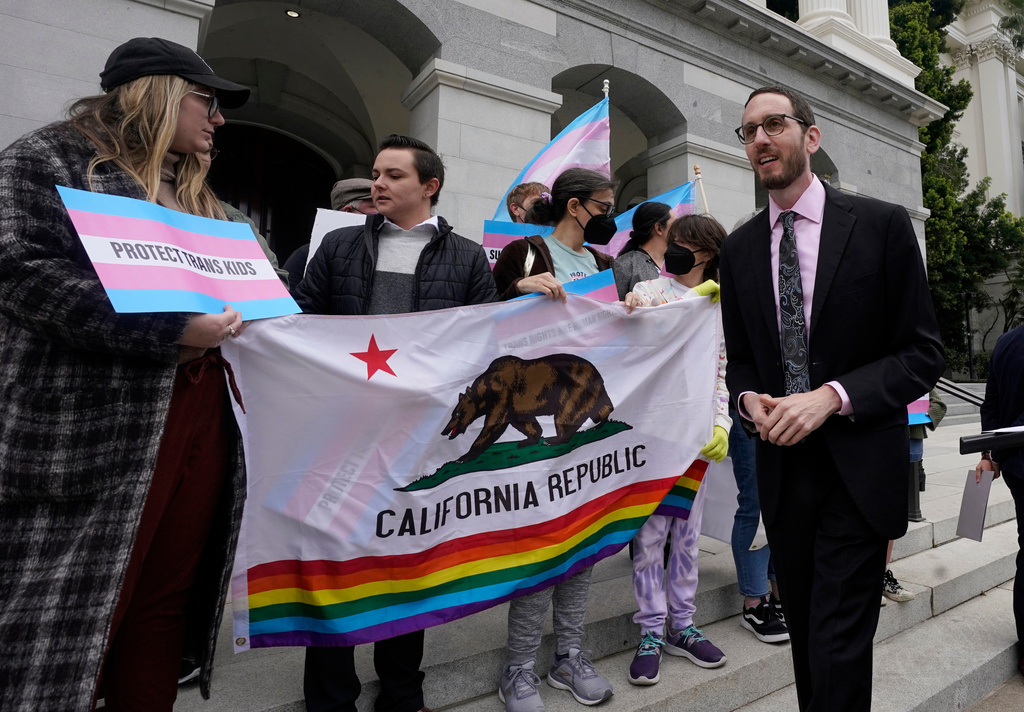 FILE - State Sen. Scott Wiener, D-San Francisco, right, prepares to announce his proposed measure to provide legal refuge to displaced transgender youth and their families during a news conference in Sacramento, Calif., on March 17, 2022. (AP Photo/Rich Pedroncelli, File)
