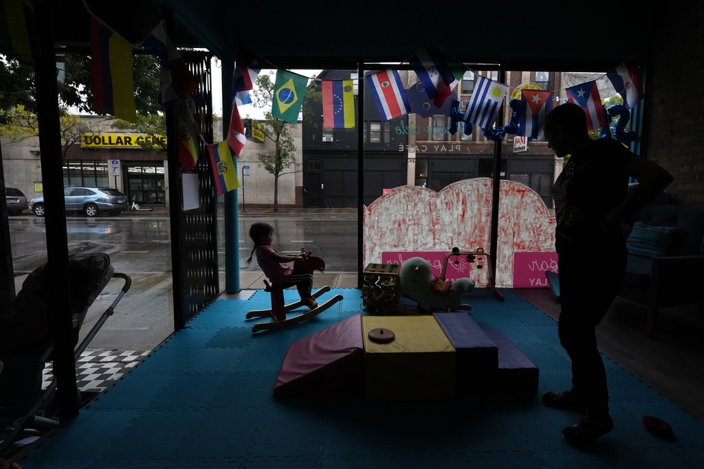 A girl rides a rocking horse as her grandmother looks o inside Luna y Cielo Play Cafe in Chicago's Logan Square neighborhood, Wednesday, Oct. 15, 2025. (AP Photo/Rebecca Blackwell)