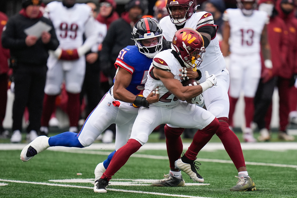 New York Giants linebacker Abdul Carter (51) tackles Washington Commanders running back Jeremy McNichols (26) during the first quarter of an NFL football game, Sunday, Dec. 14, 2025, in East Rutherford, N.J. (AP Photo/Seth Wenig)