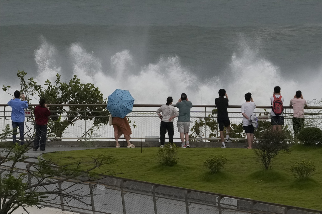 Residents brace strong winds as they watch waves crashing on a seaside ahead of Super Typhoon Ragasa in Shenzhen in southern China's Guangdong province on Tuesday, Sept. 23, 2025. (AP Photo/Ng Han Guan)