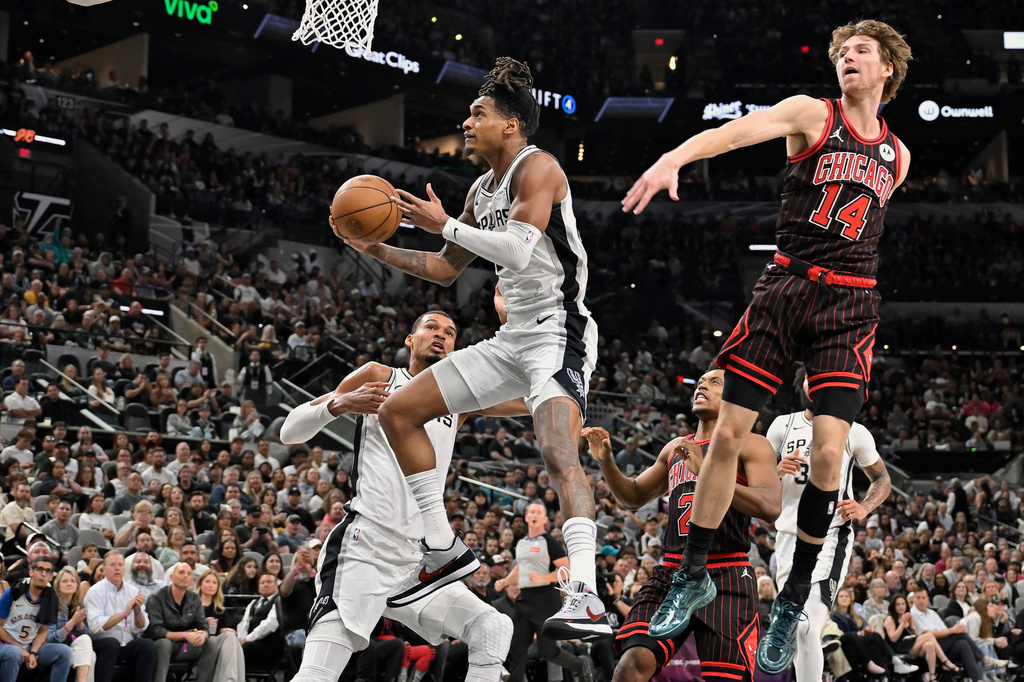 San Antonio Spurs guard Devin Vassell goes to the basket as he is guarded by Chicago Bulls forward Matas Buzelis (14) during the first half of an NBA basketball game, Monday, March 30, 2026, in San Antonio. (AP Photo/Darren Abate)