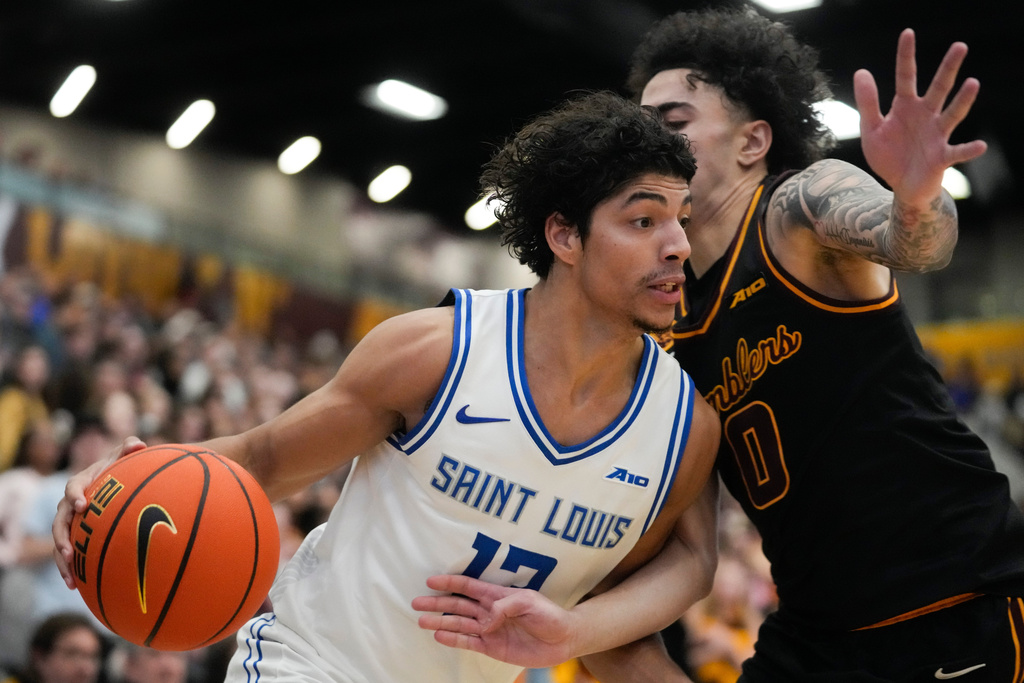 Saint Louis guard Dion Brown, left, handles the ball as Loyola Chicago guard Deywilk Tavarez (0) defends during the first half of an NCAA college basketball game Friday, Feb. 13, 2026, in Chicago. (AP Photo/Erin Hooley)