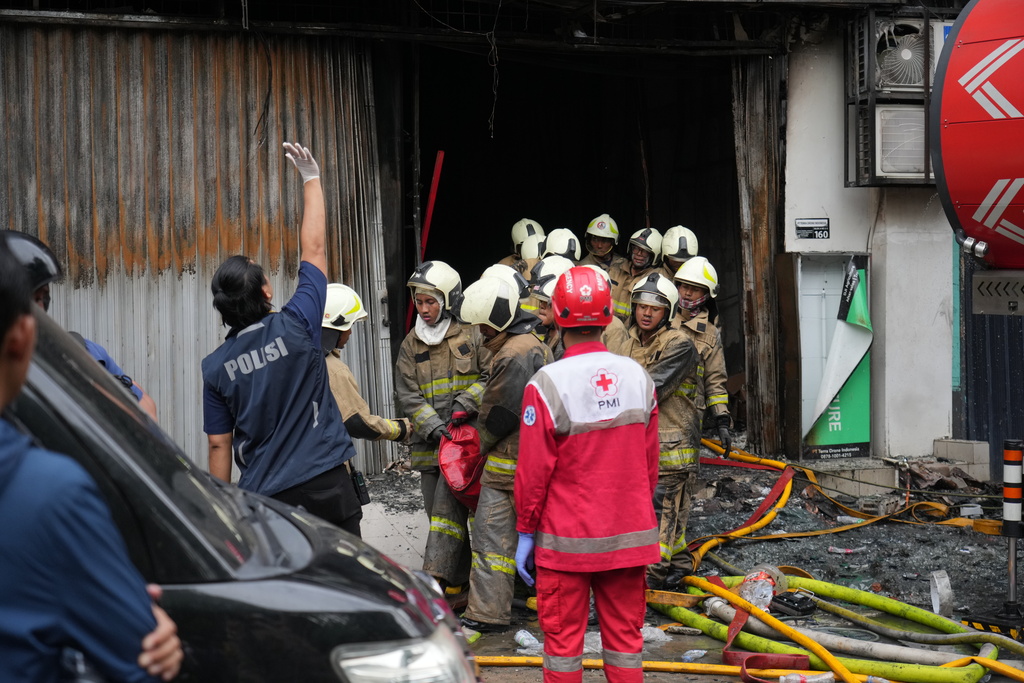 Rescuers carry out the body of a victim from the site of a fire in Jakarta, Indonesia, Tuesday, Dec. 9, 2025. (AP Photo/Dita Alangkara)