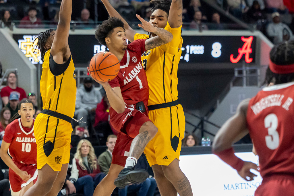 Alabama guard Jalil Bethea (1) works past Kennesaw State forward Ramone Seals, left, and guard Darius Washington III during the first half of an NCAA college basketball game, Sunday, Dec. 21, 2025, in Huntsville, Ala. (AP Photo/Vasha Hunt)