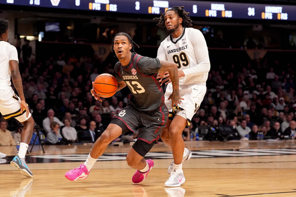 Oklahoma forward Tae Davis (13) drives against Vanderbilt forward Devin McGlockton (99) during the first half of an NCAA college basketball game Saturday, Feb. 7, 2026, in Nashville, Tenn. (AP Photo/Camden Hall)