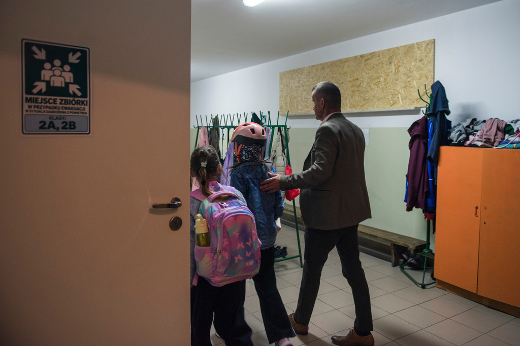Jarosław Wojcik, the school principal guides children into a school cloakroom, which has been converted into a makeshift bomb shelter, in Dorohusk, Poland, on Sept. 24, 2026. (AP Photo/Attila Husejnow)