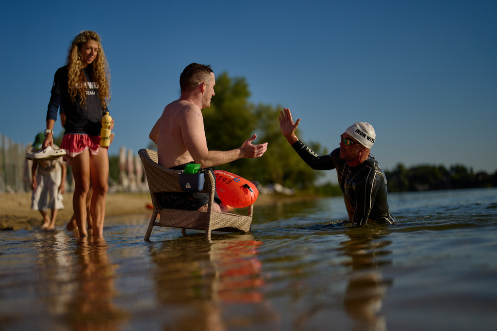 Ukrainian war veteran Maksym Yuzviak, center, is greet by sports celebrity Danylo Sapunov during an athletic event to encourage people and injured soldiers to take part in sports at a lake on the outskirts of Kyiv, Monday, Aug. 24, 2026, during the 35th anniversary of Ukraine's Independence Day. (AP Photo/Francisco Seco) Corrects spelling of Maksym Yuzviak, not Maxim Yuzvyak