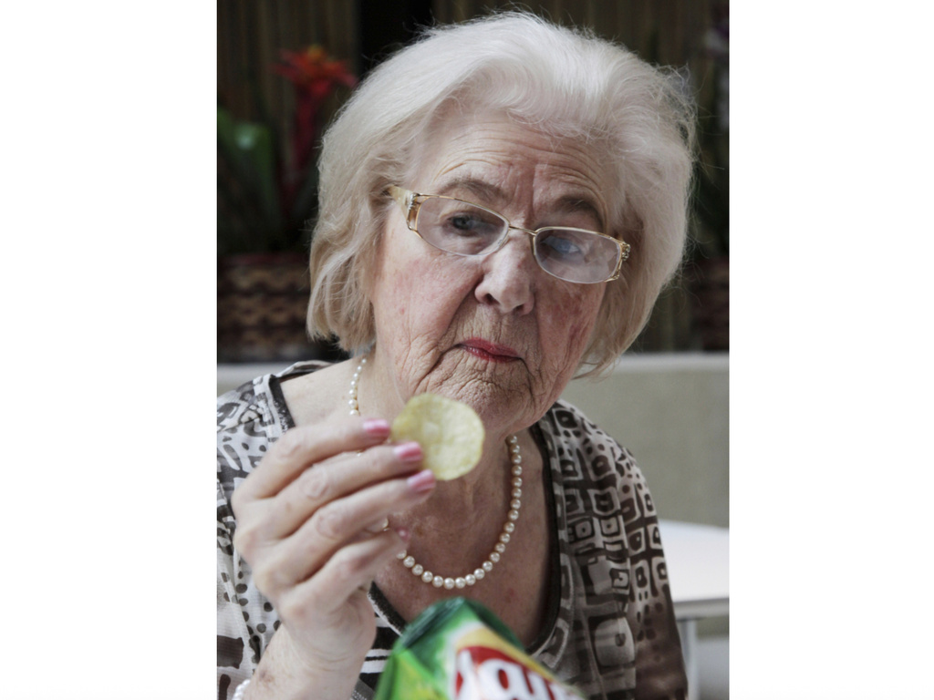 FILE - Marilyn Hagerty samples a Lays potato chip during an interview with The Associated Press, on March 14, 2012, in New York. (AP Photo/Mark Lennihan, File)