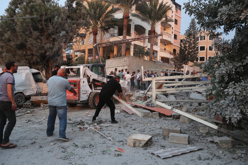 People inspect the site of a building destroyed by an Israeli airstrike in the village of Teir Debba, southern Lebanon, Thursday, Nov. 6, 2025. (AP Photo/Mohammad Zaatari)