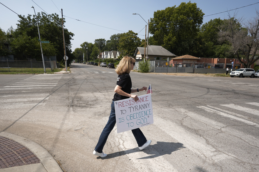 Kelly Edmondson crosses a street in a neighborhood that would be affected by a proposal to redraw Missouri's congressional districts to favor Republican candidates Thursday, Sept. 4, 2025, in Kansas City, Mo. (AP Photo/Charlie Riedel)
