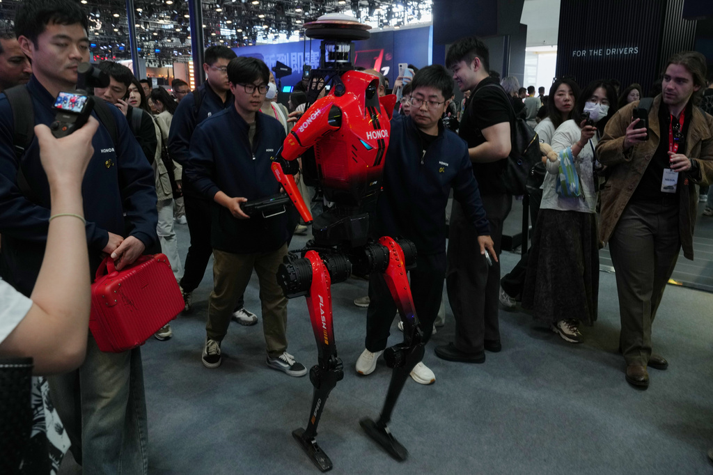 Honor, the humanoid robot which has won the humanoid robot half-marathon last weekend is surrounded by visitors as it visiting the Auto China 2026, in Beijing, Friday, April 24, 2026. (AP Photo/Andy Wong)