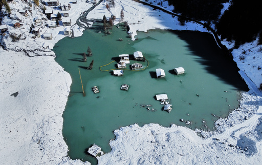 An aerial view shows the partly flooded village of Blatten after recent snowfalls, five months after a landslide destroyed the village, Blatten, Switzerland, on Tuesday, Oct. 28, 2025. (AP Photo/Michael Probst) An aerial view shows the partly flooded village of Blatten after recent snowfalls, five months after a landslide destroyed the village, Blatten, Switzerland, on Tuesday, Oct. 28, 2025. (AP Photo/Michael Probst)
