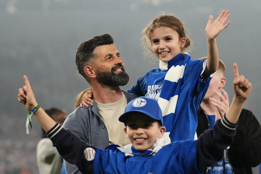 Schalke's head coach Miron Muslic celebrates with family members at the end of the German Bundesliga 2 soccer match between FC Schalke 04 and Fortuna Duesseldorf in Gelsenkirchen, Germany, Saturday, May 2, 2026. (AP Photo/Martin Meissner)