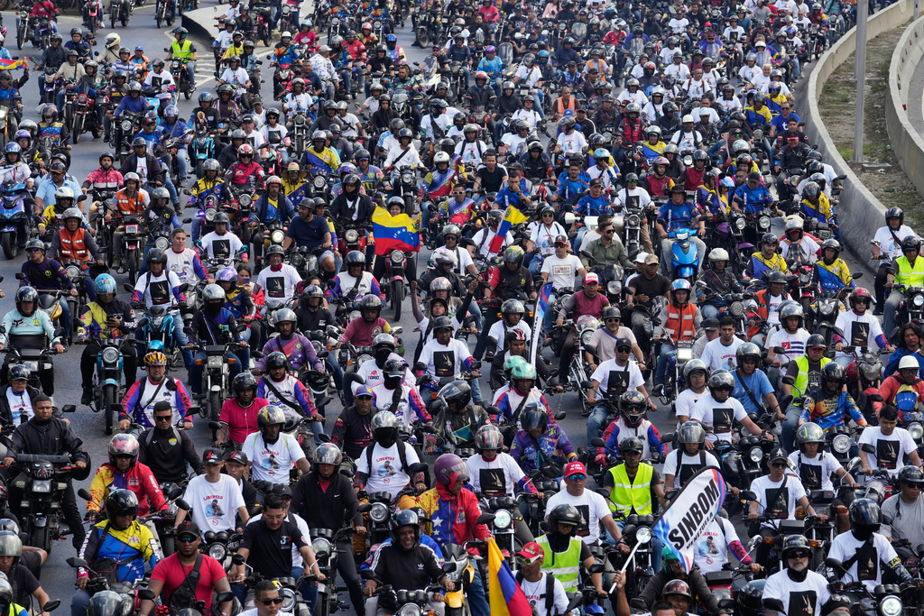 Supporters of former Venezuelan President Nicolas Maduro ride through the streets calling for his release as he faces trial in the United States after being captured by U.S. forces, in Caracas, Venezuela, Tuesday, Jan. 13, 2026. (AP Photo/Matias Delacroix)