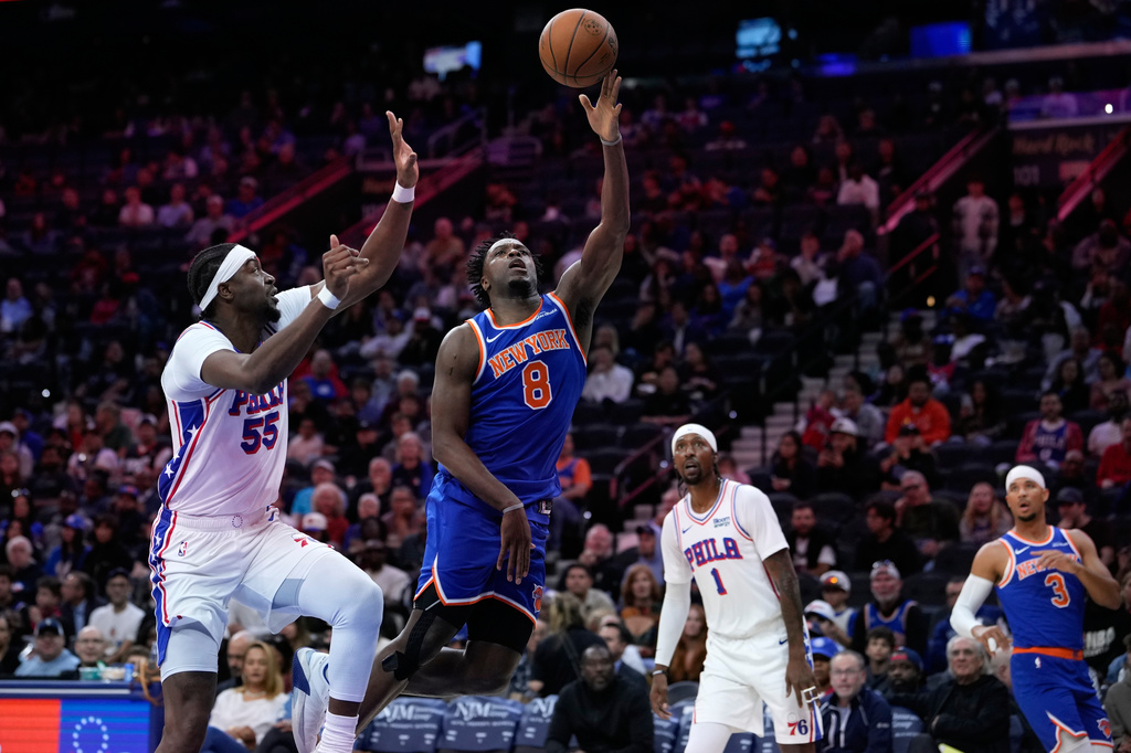 New York Knicks' Og Anunoby (8) goes up for a shot against Philadelphia 76ers' Ariel Hukporti (55) during the first half of a preseason NBA basketball game Monday, Oct. 5, 2026, in Philadelphia. (AP Photo/Matt Slocum)