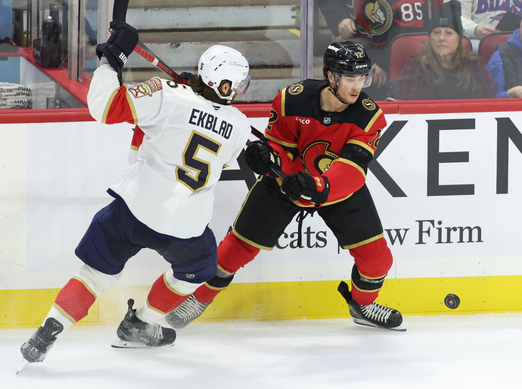 Florida Panthers' Aaron Ekblad (5) and Ottawa Senators' Shane Pinto (12) battle for the puck during second period NHL hockey action in Ottawa on Saturday, Jan. 10, 2026. (Patrick Doyle/The Canadian Press via AP)
