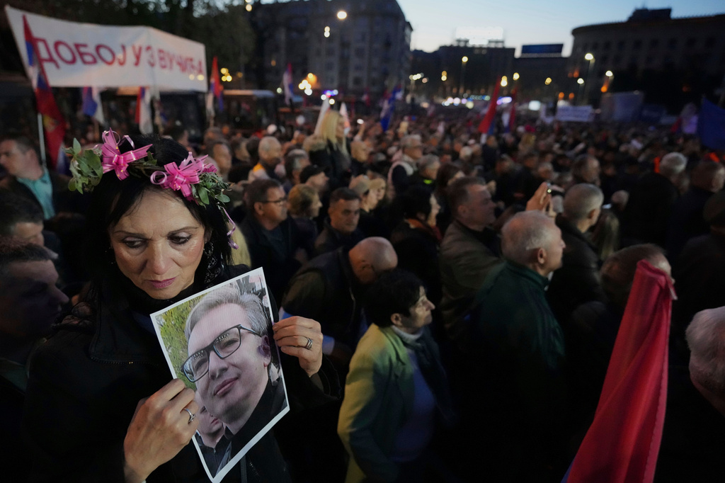 FILE - A supporter of Serbia's President Aleksandar Vucic holds his photo during a rally in Belgrade, Serbia, April 12, 2025. (AP Photo/Darko Vojinovic, File)
