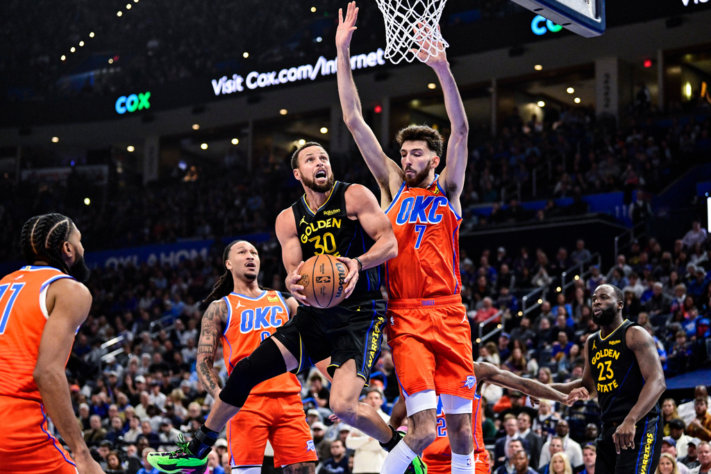 Golden State Warriors guard Stephen Curry (30) looks to shoot against Oklahoma City Thunder center/forward Chet Holmgren (7) during the first half of an NBA basketball game, Tuesday, Nov. 11, 2025, in Oklahoma City. (AP Photo/Gerald Leong)