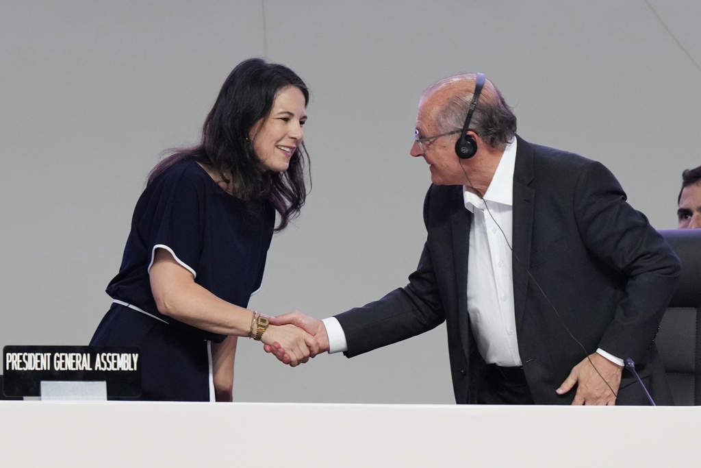 Brazil Vice President Geraldo Alckmin, right, shakes hands with U.N. General Assembly President Annalena Baerbock during a plenary session at the COP30 U.N. Climate Summit, Monday, Nov. 17, 2025, in Belem, Brazil. (AP Photo/Fernando Llano)