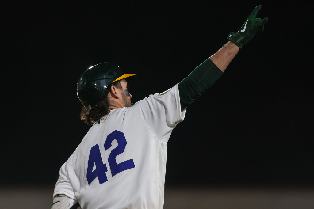 Athletics' Jacob Wilson gestures to the bullpen after hitting a two-run home run during the seventh inning of a baseball game against the Texas Rangers, Wednesday, April 15, 2026, in West Sacramento, Calif. (AP Photo/Scott Marshall)