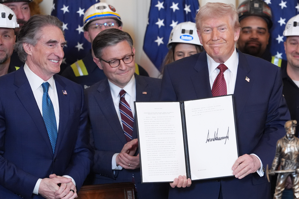 President Donald Trump holds an executive order regarding coal during an event in the East Room of the White House, Wednesday, Feb. 11, 2026, in Washington, as Interior Secretary Doug Burgum, House Speaker Mike Johnson of La., and coal miners watch. (AP Photo/Evan Vucci)
