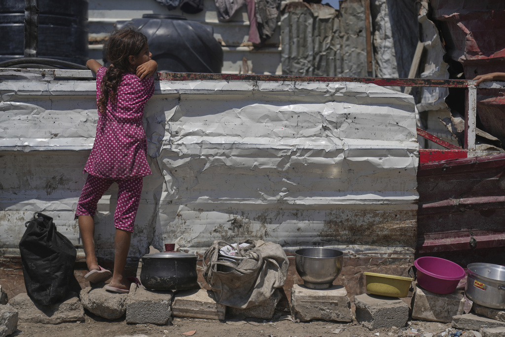 A Palestinian girl waits at a community kitchen before donated food is distributed in Gaza City, Friday, Aug. 22, 2025. (AP Photo/Abdel Kareem Hana)