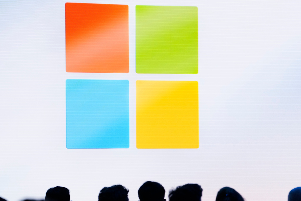 FILE - A Microsoft logo is seen on a screen as people listen at an event at Microsoft headquarters, May 20, 2024, in Redmond, Wash. (AP Photo/Lindsey Wasson, File)