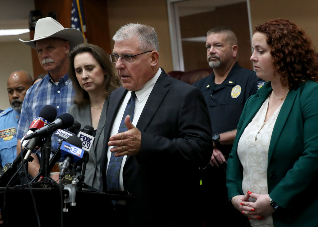 Galveston County District Attorney Kenneth Cusick, center, flanked by law enforcement officers from across the county and Assistant District Attorney Kate Willis, right, holds a news conference, in downtown Galveston, Texas, on Wednesday, April 1, 2026. (Jennifer Reynolds /The Galveston County Daily News via AP)