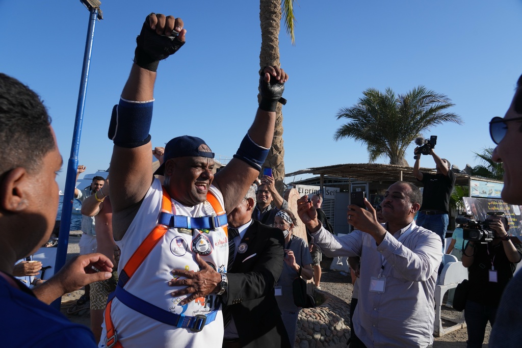 Egyptian wrestler Ashraf Mahrous, better known as Kabonga, celebrates after pulling a 700-ton ship across the water using only a rope held in his teeth at the marina in the Red Sea resort of Hurghada, Egypt, Saturday, Sept. 27, 2025. (AP Photo/Amr Nabil)