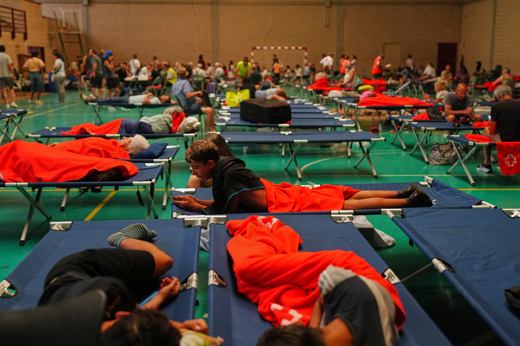 Residents spend the night at a sports center after being evacuated from their homes because of the threat of a wildfire in Cebreros, Ávila province, Spain, Friday, July 24, 2026. (AP Photo/Manu Fernandez)