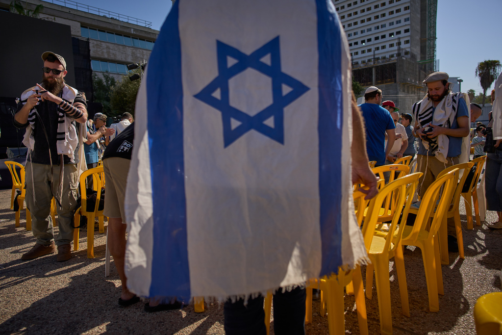 People attend a tefillin-laying ceremony led by freed hostage Bar Kupershtein, an Israeli recently released from Hamas captivity in Gaza, at a plaza known as Hostages Square, in Tel Aviv, Israel, Friday, Oct. 31, 2025. (AP Photo/Oded Balilty)