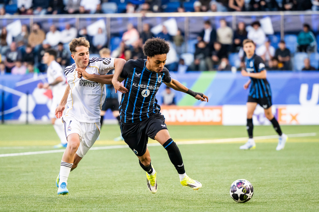 Real Madrid's Daniel Yanez, left, and Club Brugge's Andre Garcia, right, challenge for the ball during the Youth League final soccer match between Club Brugge and Real Madrid in Lausanne, Switzerland, Monday, April 20, 2026. (Jean-Christophe Bott/Keystone via AP)