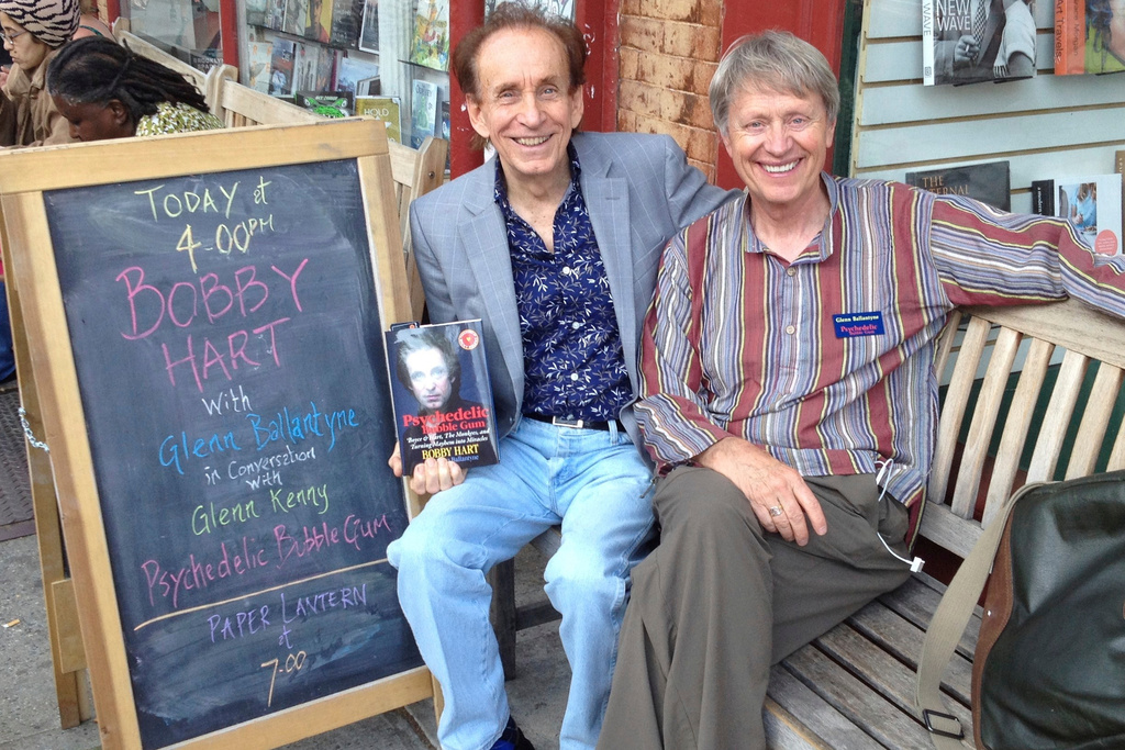 This photo provided by Glenn Ballantyne shows Bobby Hart, left and Glenn Ballantyne seated next to a message board at a book signing for Psychedelic Bubble Gum on May 30, 2015 at Book Court bookstore 163 Court Street in Brooklyn, New York. ( Glenn Ballantyne via AP)