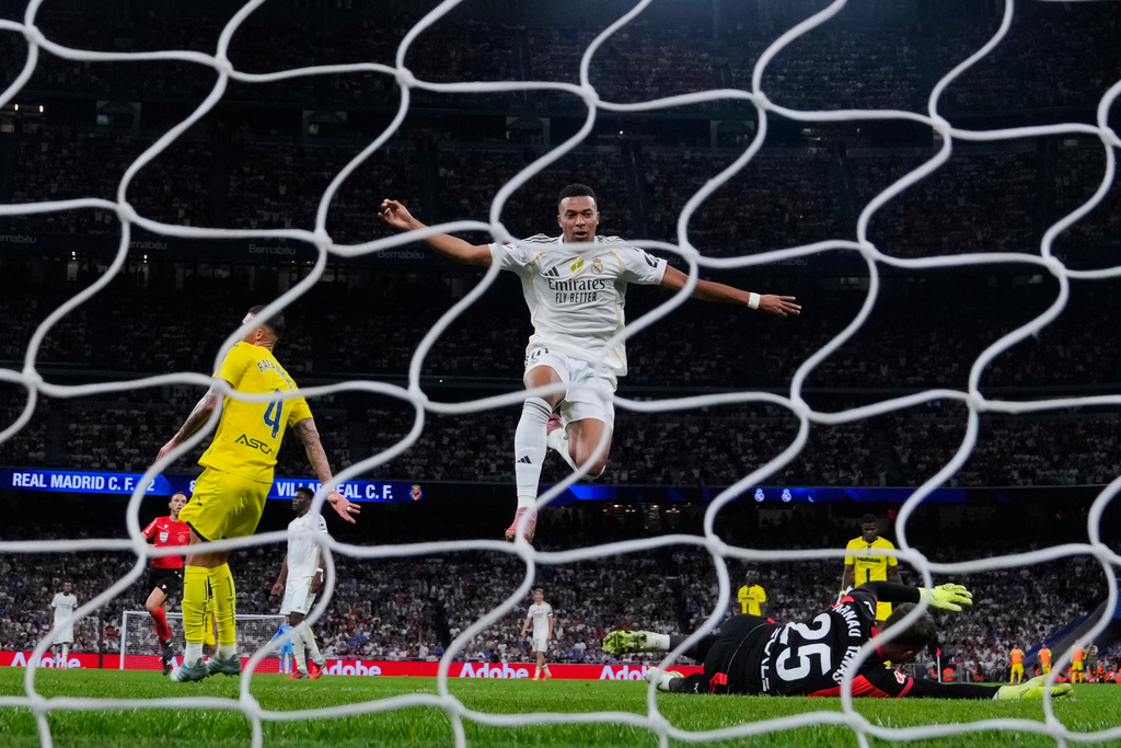 Real Madrid's Kylian Mbappe, centre, celebrates after scoring his side's third goal during the Spanish La Liga soccer match between Real Madrid and Villarreal at the Santiago Bernabeu stadium in Madrid, Spain, Saturday, Oct. 4, 2025. (AP Photo/Manu Fernandez)
