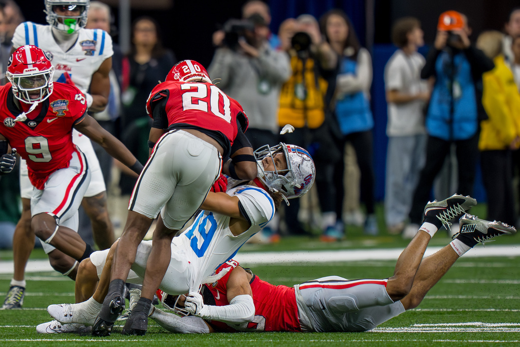 FILE - Georgia defensive back Jacorey Thomas (20), who ejected for targeting, hits Mississippi wide receiver Cayden Lee (19) causing Lee's mouthpiece to come out as Georgia defensive back Daylen Everette (6) tackles from below during the first half of the Sugar Bowl NCAA college football playoff quarterfinal game, Thursday, Jan. 1, 2026, in New Orleans. (AP Photo/Matthew Hinton, File0