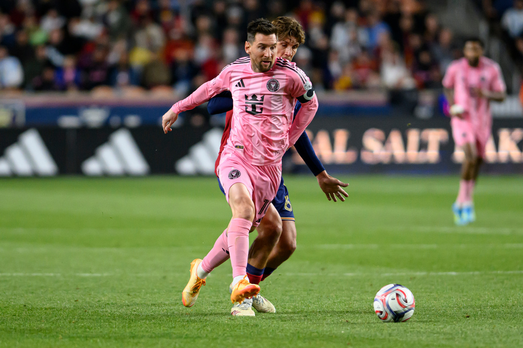 Inter Miami midfielder Lionel Messi, left, dribbles around Real Salt Lake defender Juan Manuel Sanabria, center rear, during an MLS soccer match, Wednesday, April 22, 2026, in Sandy, Utah. (AP Photo/Tyler Tate)