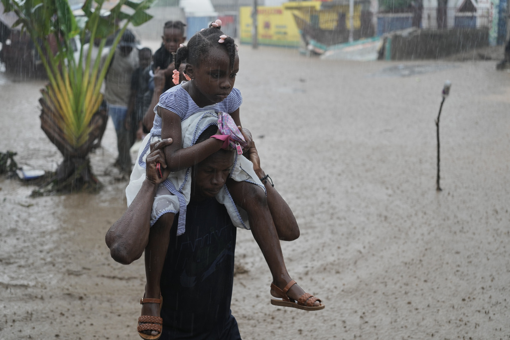 Residents wade through a flooded street in the aftermath of Hurricane Melissa in Petit-Goave, Haiti, Thursday, Oct. 30, 2025. (AP Photo/Odelyn Joseph)
