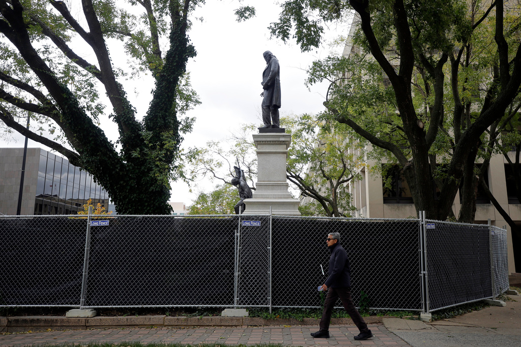 A person walks past the closed off area around where a statue of Confederate general Albert Pike has been reinstalled near the headquarters of the Department of Labor, Tuesday, Oct. 28, 2025, in Washington. (AP Photo/Rahmat Gul)