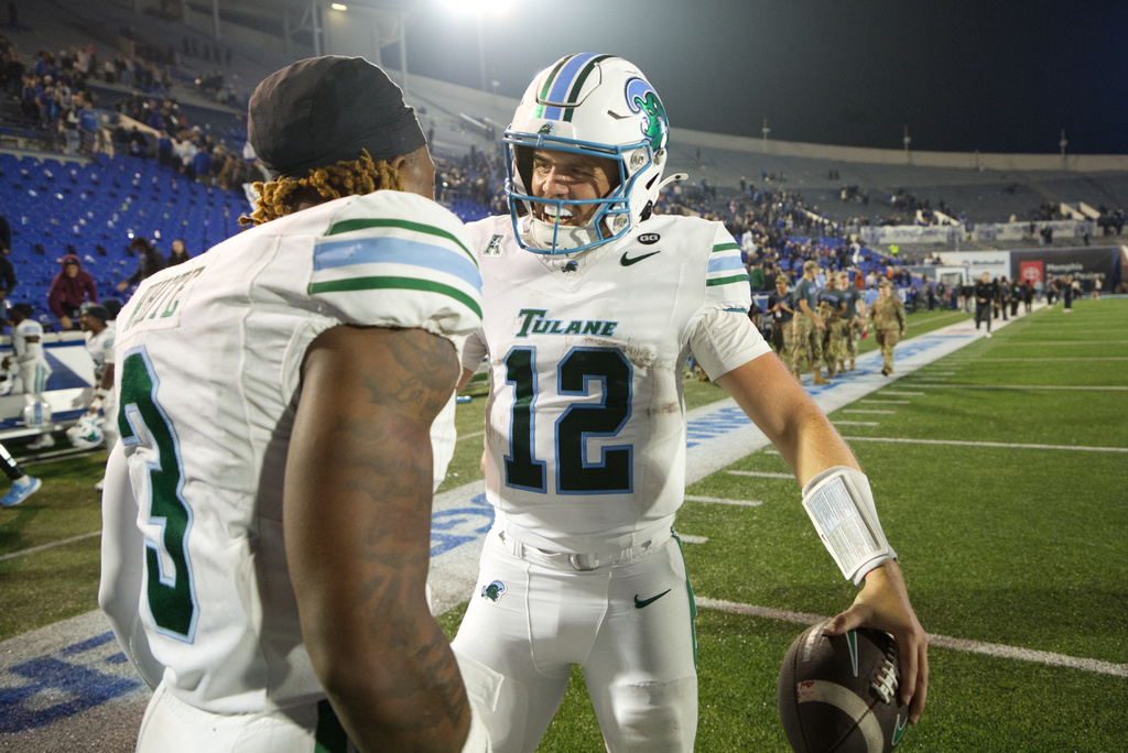 Tulane quarterback Jake Retzlaff (12) celebrates with Tulane defensive back Javion White (3) after defeating Memphis in an NCAA college football game, Friday, Nov. 7, 2025, in Memphis, Tenn. (AP Photo/Nikki Boertman)