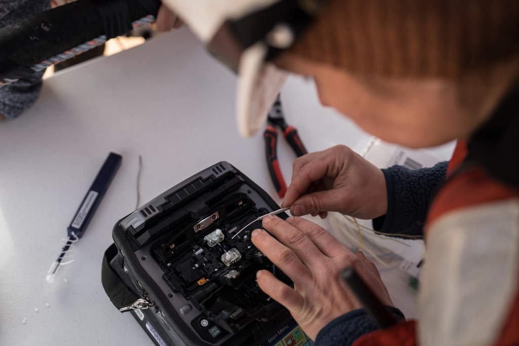 Isabelle Brandicourt, a graduate student at the University of Washington School of Oceanography, prepares to fuse fibers on a barge off San Juan Island, Wash., Friday, Oct. 10, 2025. (AP Photo/Annika Hammerschlag)